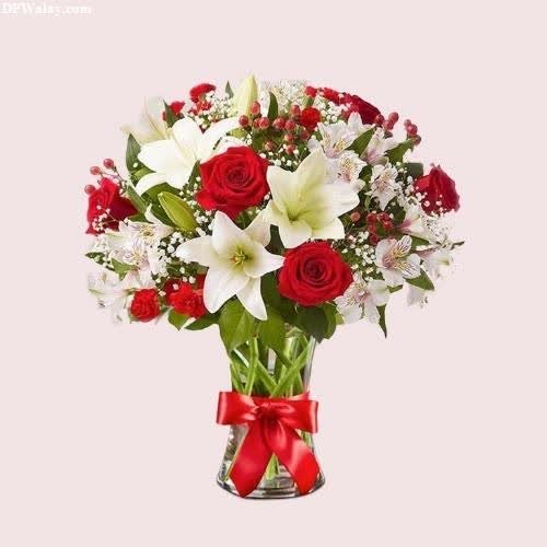 a vase filled with red roses and white lilies