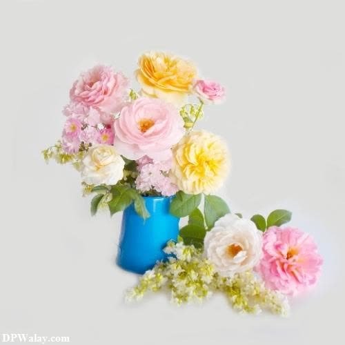a blue vase filled with pink and yellow flowers