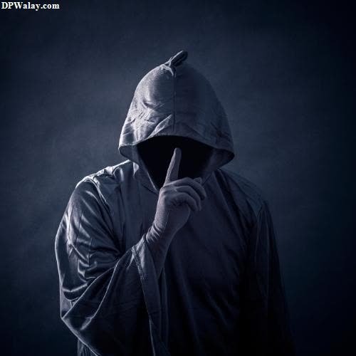 a man in a hoodie standing in the dark