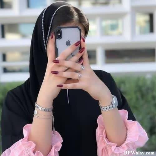 a woman in a black hina is taking a selfie 