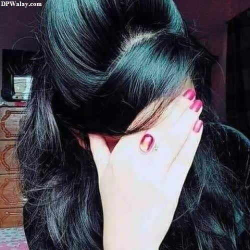 a woman with long black hair and pink nails