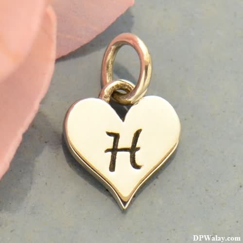 a gold heart charm with a small initial-AyAL h name wallpaper