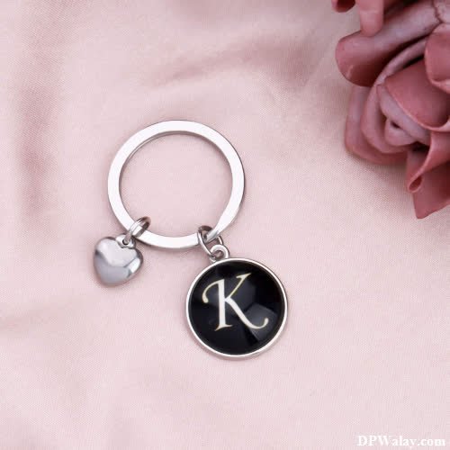 a black and white initial keychai with a heart charm