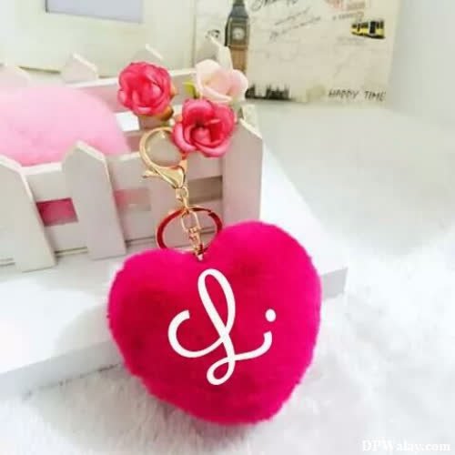 a pink heart shaped keychai with a white heart l letter dp
