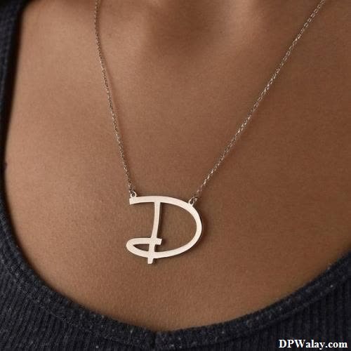 a woman wearing a silver necklace with the letter d on it 