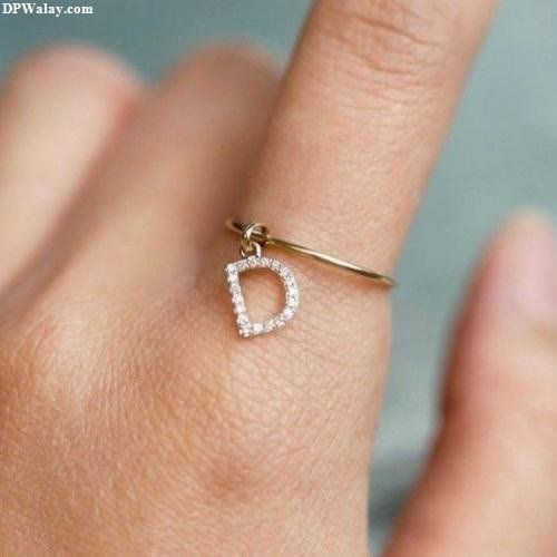 D Name DP - a woman's hand with a gold ring with a diamond