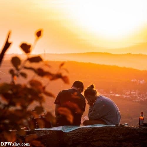 a couple sitting on a hill watching the sunset love dp couple