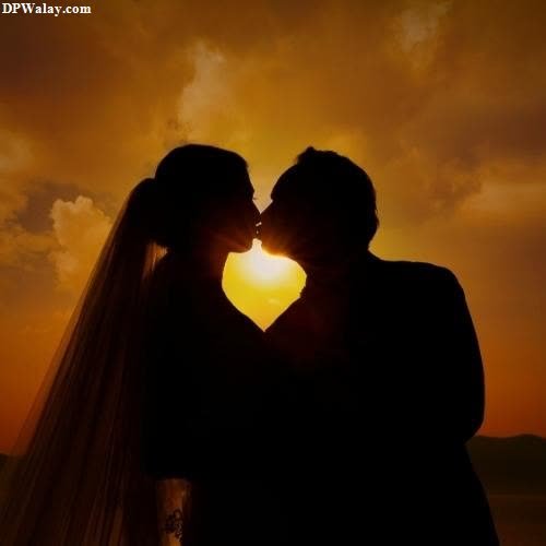 a couple kissing in the sunset 