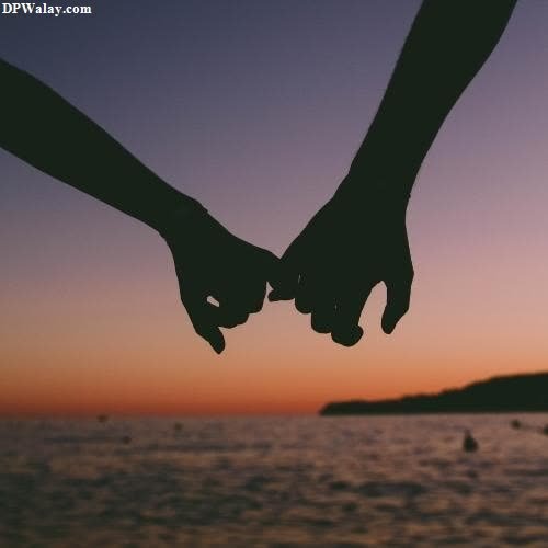 two people holding hands with the sunset in the background images by DPwalay