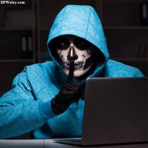 a person in a blue hoodie using a laptop
