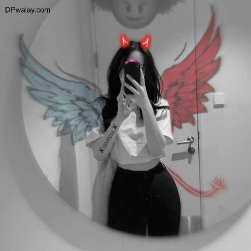 a girl with wings on her face is reflected in a mirror